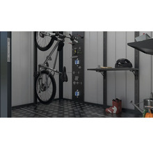 Een garage-interieur met een fiets aan een muurbeugel, gereedschap aan een geperforeerde plaat, planken en diverse accessoires zoals een helm en rubberlaarzen.