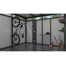 Interieur van een tuinhuis met fiets, gereedschap, planken en tuingereedschap