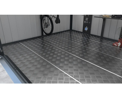 Gestructureerde metalen vloer in een opslagruimte met fiets, werkbank en gereedschapswand