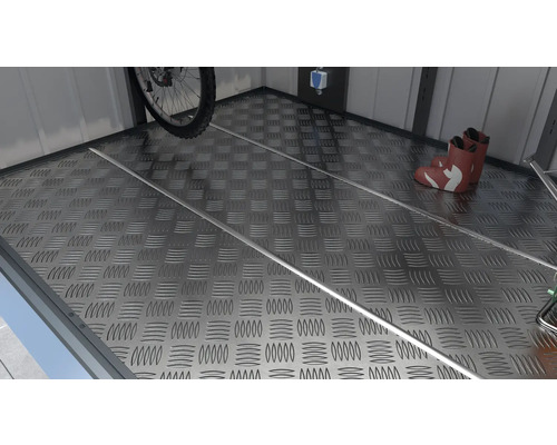 Metalen vloer met traanplaatpatroon, fiets en laarzen in de tuinschuur