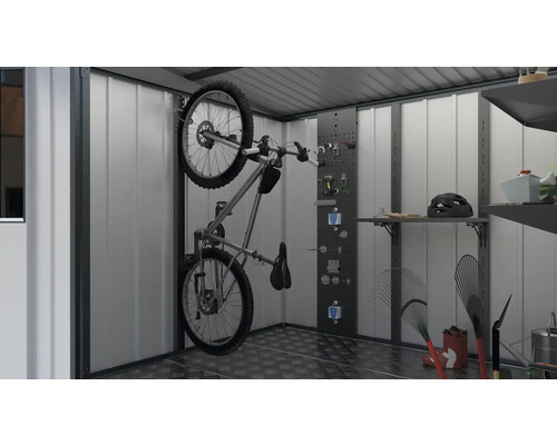 Fiets aan de muur in tuinhuis met rekken en gereedschapswand.