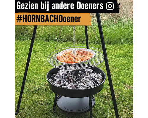 Driepootbarbecue met houtskool en gegrild voedsel in de tuin