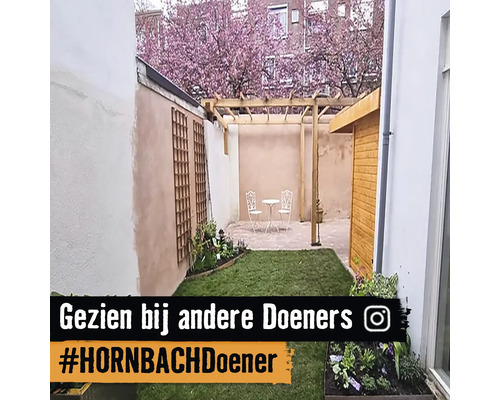 Aangelegde tuin met pergola, zitgroep en houten wand