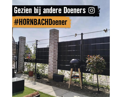 Tuin met metalen hekwerk en barbecueplaats