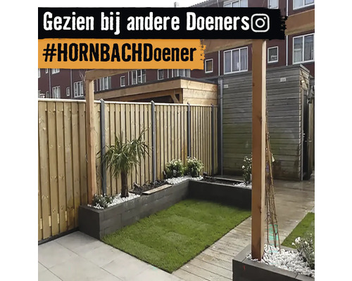 Aangelegde tuin met houten schutting, gazon en plantenbakken