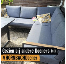 Grijze tuinlounge met tafel en kussens op een terras