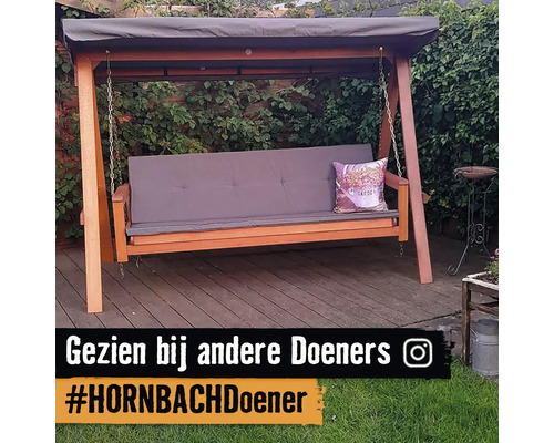 Houten schommel met luifel en zitkussen in de tuin