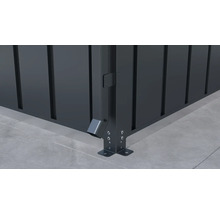 Detailopname van een metalen hoek van een hek met regenafvoer en grondbevestiging