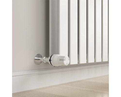 Close-up van een witte radiator met thermostaat aan een muur