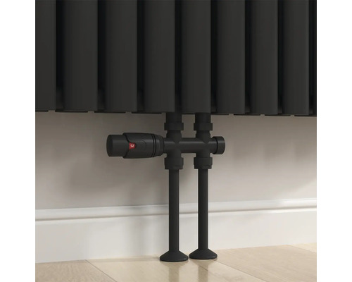 Close-up van een radiator met thermostatische kraan en leidingen