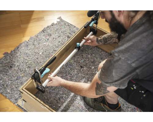 Ambachtsman bevestigt een spanstang tussen twee zijden van een houten frame