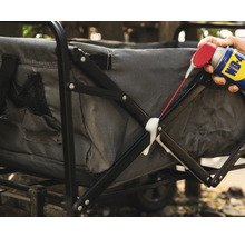 Iemand spuit een multifunctioneel product op een bolderkar.