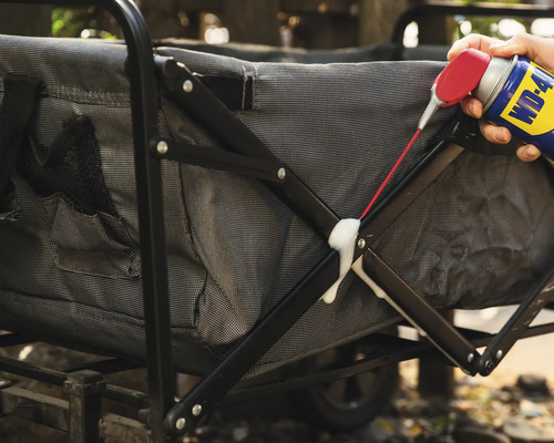 Iemand spuit een multifunctioneel product op een bolderkar.