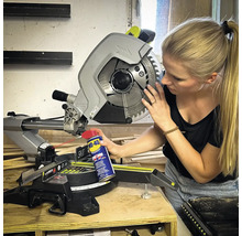 Een vrouw onderhoudt een verstekzaag met een multifunctionele spray.