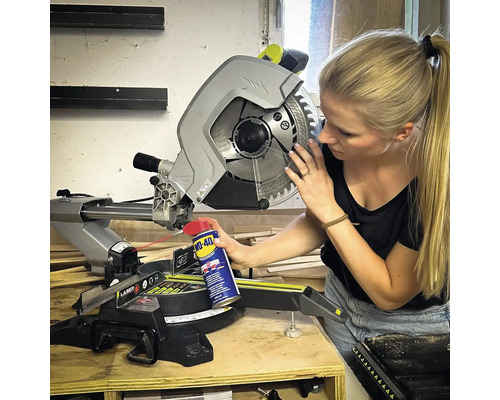 Een vrouw onderhoudt een verstekzaag met een multifunctionele spray.