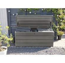 Geopende grijze tuinkist met kussens in de tuin