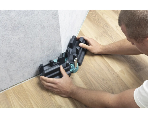 Persoon gebruikt een verstekbak voor het snijden van plinten.