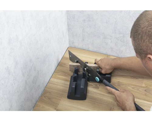 Handzaag met verstekbak tijdens het zagen van een stuk hout