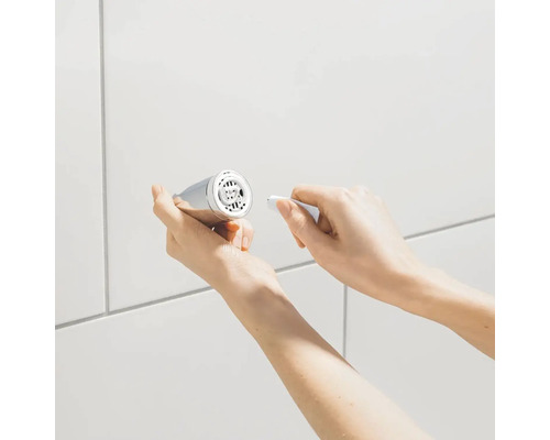 Handen reinigen een kraan perlator met een gereedschap voor een witte achtergrond