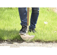 Persoon die een spade in het gras gebruikt.