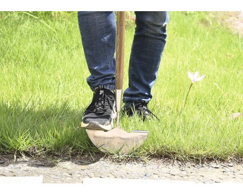 Persoon die een spade in het gras gebruikt.