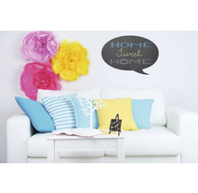 Woonkamer met witte bank, kussens, tafel, decoratie en muursticker