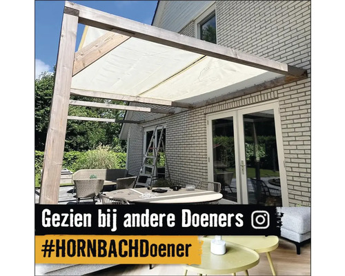 Terras met zonnescherm en tuinmeubelen voor een bakstenen huis