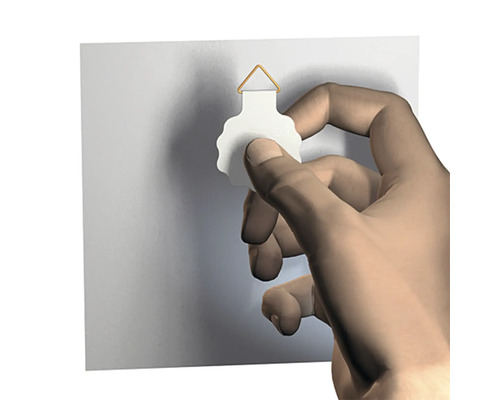 Hand bevestigt een fotolijsthaak aan de muur