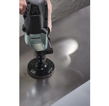 Een schuurmachine met schuurschijf wordt gebruikt op een metalen oppervlak.