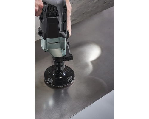 Een schuurmachine met schuurschijf wordt gebruikt op een metalen oppervlak.