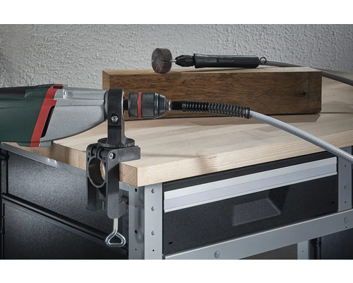 Boormachine met gemonteerde tafelklem en flexibele as op een werkbank.