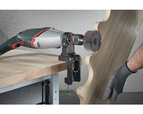 Elektrisch gereedschap met schuurschijf bewerkt hout met houder aan tafel bevestigd