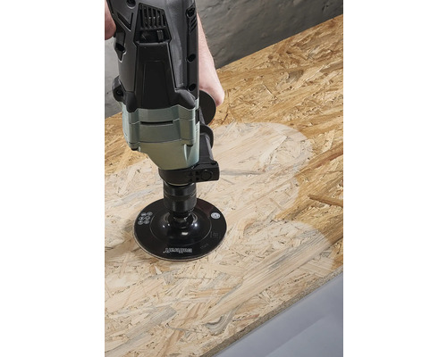 Een schuurmachine bewerkt een houten plaat.