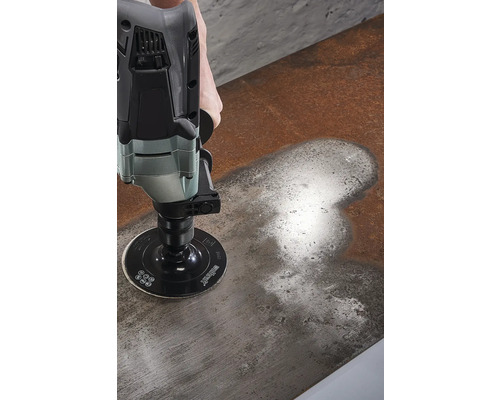 Iemand schuurt een metalen oppervlak met een schuurmachine.