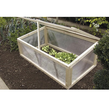 Houten en kunststof koude bak in een tuinbed met sla planten