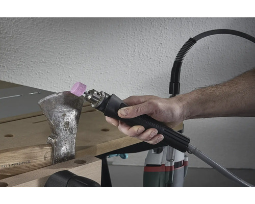 Iemand slijpt een bijl met een slijptool.