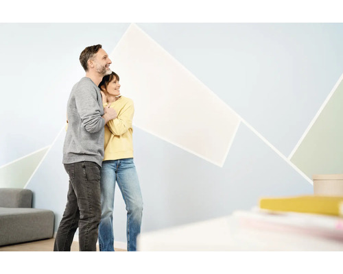 Stel bekijkt geometrisch wanddesign in de woonkamer.
