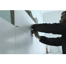 Tegelzetter aan het werk met tegels en tegeldraden