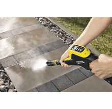 Een persoon reinigt bestrating met een Kärcher hogedrukreiniger.