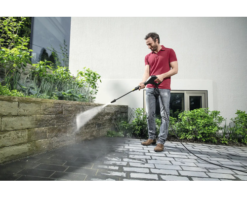 Man reinigt terras met hogedrukreiniger.