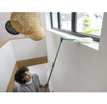 Vrouw reinigt vensterbank met een plumeau.