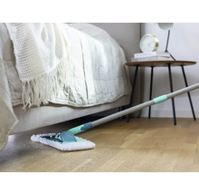 Scene van een kamer met bed, nachtkastje en dweil op een houten vloer.