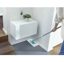 Schoonmaakster dweilt de vloer in de entree met een mop