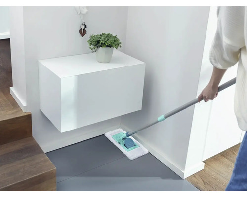 Schoonmaakster dweilt de vloer in de entree met een mop