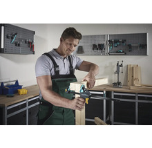 Man fixeert houten stukken met een éénhandsklem in een werkplaats