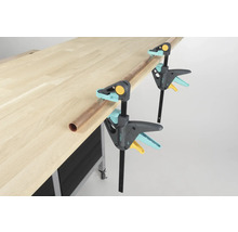 Werkbank met twee Wolfcraft eenhandklemmen en een koperen buis.