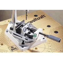 Wolfcraft Logo. Boorkolom met bankschroef op een werkbank