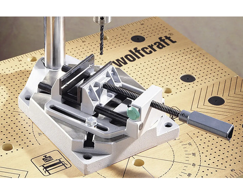 Wolfcraft Logo. Boorkolom met bankschroef op een werkbank