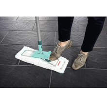 Vloermop in gebruik op donkere tegels, bediend door een persoon met schoenen.