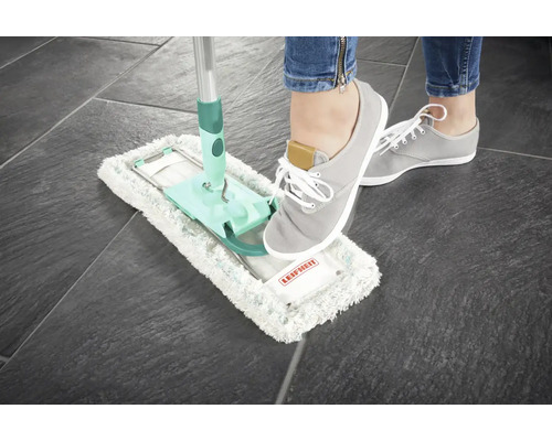 Vlak dweilsysteem met voet op het reinigingsoppervlak op een tegelvloer